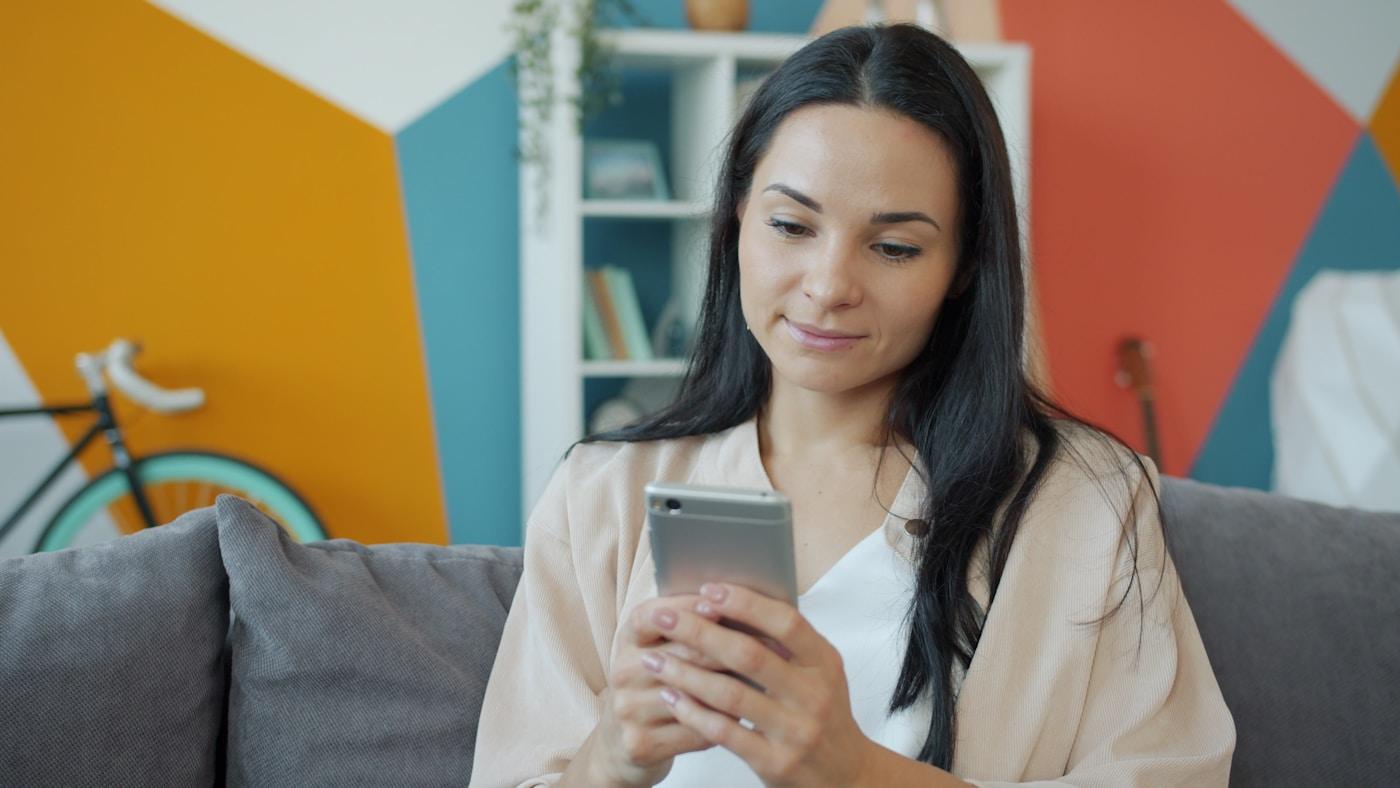 Mujer usando su celular en casa